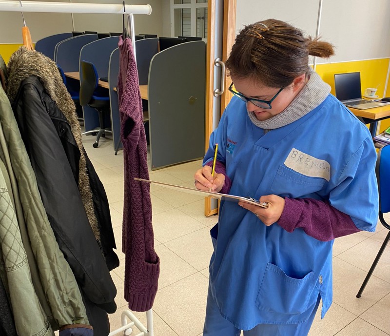 La compañera, con una libreta haciendo un primer listado de los artículos.