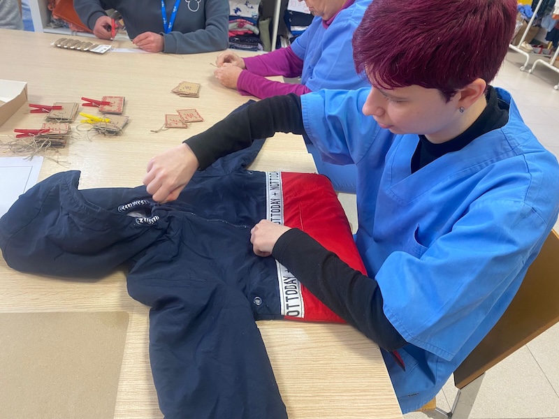 Nuestra compañera comprobando que la prenda está correcta, extendiendola encima de una mesa.